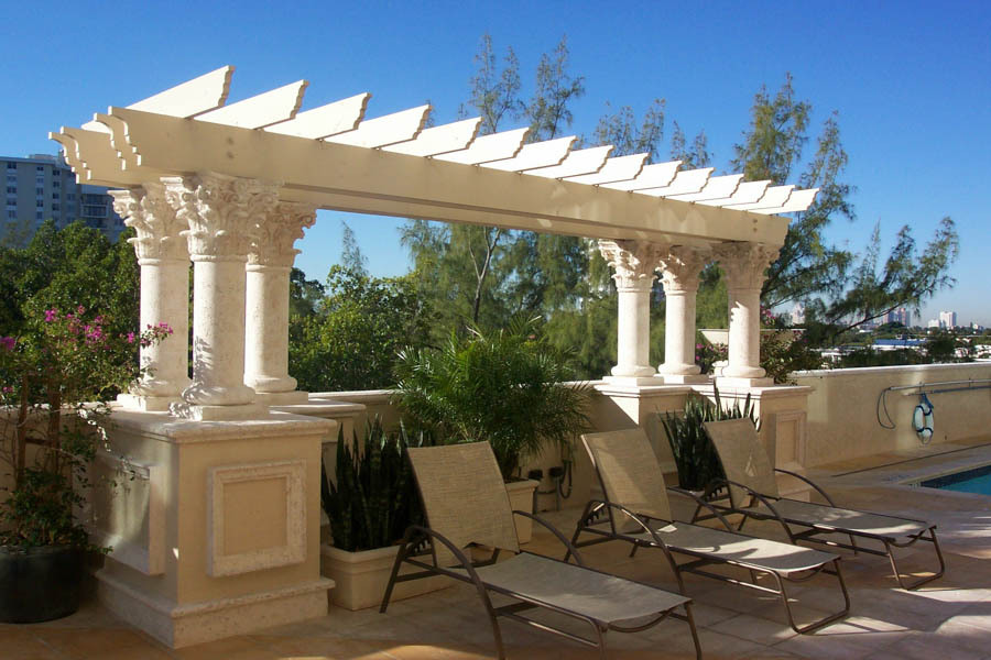 Classical white-column pergola with loungers on a waterfront deck