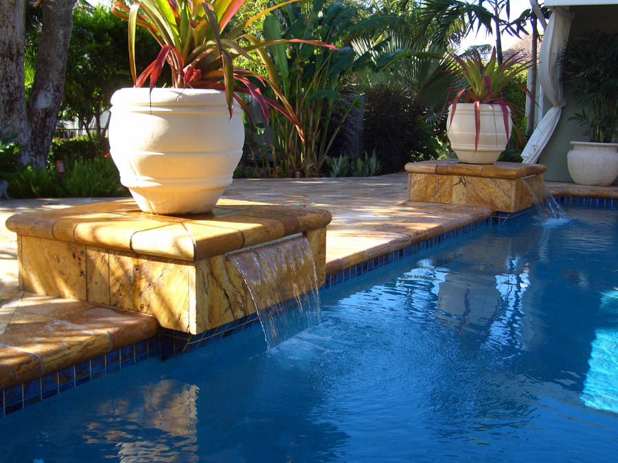 Pool with spillover urn planters and stone coping