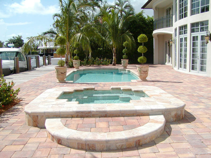Raised spillover spa with a paver deck